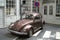 Closeup of a brown vintage Volkswagen beetle with a traffic light in its hood