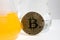 Closeup of a BTC bitcoin coin surrounded by chemicals and lab glassware.