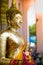 CLoseup Buddhist statue coated by the golden laef and hang by fl