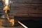 Closeup of a burning old antique hurricane oil lamp with closed book on wooden table