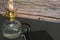 Closeup of a burning old antique hurricane oil lamp with closed book on wooden table