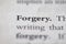 Closeup of Business legal term Forgery printed in textbook on white page.