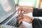 Closeup of business woman hand typing on laptop keyboard .