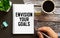 Closeup on businessman holding a card with text ENVISION YOUR GOALS