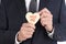 Closeup of a businessman holding a heart shaped cookie with the words Hug Me written in red icing.  Man is unrecognizable