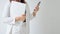 Closeup Businesswoman in office dress code standing holding laptop and smartphone