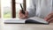 Closeup businesswoman sit at table makes notes in personal organizer