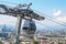 Closeup of cable car over the roofs of Tbilisi Georgia with city spread out below and mountains in the distance