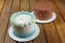 Closeup of cake with buttercream frosting next to cake with semisweet chocolate ganache frosting
