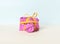 Closeup of a camera wrapped in magenta gift paper and yellow ribbon on a pastel background