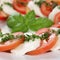 Closeup Caprese salad with tomatoes and mozzarella cheese on plate