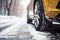 Closeup of car tires in winter on the road covered with snow