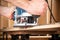 Closeup of carpenter with hand wood router machine at work. closeup of routing bevel into plank of pine woodworking construction