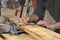 closeup of carpenter marking line on wooded board with pencil and wooden square during home remodel