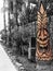 Closeup carved tiki gods on alife palm trees outdoor