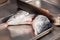 Closeup carving whole fresh norwegian salmon fish with heads on red cutting board in professional kitchen restaurant, preparing