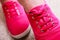 Closeup of casual vibrant pink sneakers shoes boots on female feet