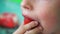 Closeup Caucasian boy with an appetite eats fresh strawberries, puts a finger in his mouth with pleasure. Fresh berry from the gar