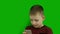 Closeup caucasian boy talking via messenger on smartphone with loved ones on a green background. Green screen.