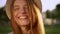 Closeup caucasian cheerful girl in hat with amazing red long hair laughing looking at camera during bright sunny day on