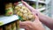 Closeup caucasian woman hands near shop shelves choosing marinade mushrooms in grocery market