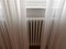 Closeup of the central heating radiator covered with light curtains