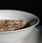 Closeup of a ceramic bowl with brown flake cereal and milk in it