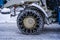 Closeup of a chained wheel of a snowy snow plow .