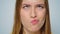 Closeup cheerful woman making funny faces on grey background in studio.