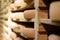 Closeup of cheese crusts on traditional wood shelves in cellar