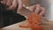 Closeup chef hands cutting slices of tomato on wood cutting board