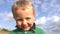 Closeup, child boy smiling and grimacing. Real emotions, boy on a sky background