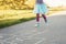 Closeup of child girl playing jumping hopscotch outdoors. Funny activity game for kids on playground outside. Summer backyard