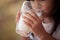 Closeup child hand holding and drinking a milk from glass