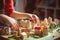 Closeup of child\\\'s hands arranging miniature town model with detailed buildings and trees