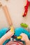 Closeup of child`s hands playing with wooden train toys and railway. Top view. Toddler boy sitting and playing with railroad indo