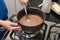 Closeup of child`s hands stirring with a spoon to make brigadeiro, Brazilian sweet