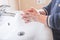 Closeup of a child`s soapy hands being washed under running water in a sink