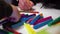 Closeup children drawing together on paper sheet with focus on colored markers