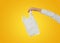 Closeup children hand holding a white thin polythene plastic bag isolated on yellow background