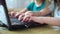 Closeup of children hands playing online computer games on laptop