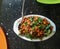 Closeup of chinese corn chilli in a white platter in the table, food photography, spring onions garnish