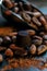 Closeup chocolate candy around cocoa beans with measuring scoop on blackstone background