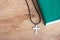 Closeup christian cross and bible on old wooden table with sunlight.