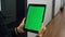 Closeup chroma key tablet in manager hands. Unknown woman walking hallway talk