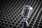 Closeup of chrome retro condenser microphone on acoustic foam panel background