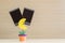 Closeup clamp photo in yellow moon shape in flowerpot with black blank film on blurred wooden desk and wall background