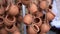 Closeup of clay ceramic pots hanging on ropes and fluttering on wind