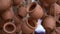 Closeup of clay ceramic pots hanging on ropes and fluttering on wind