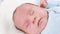 Closeup of cleaning and washing baby\'s face with soft cotton pad. Concept of babies and newborn hygiene and healthcare